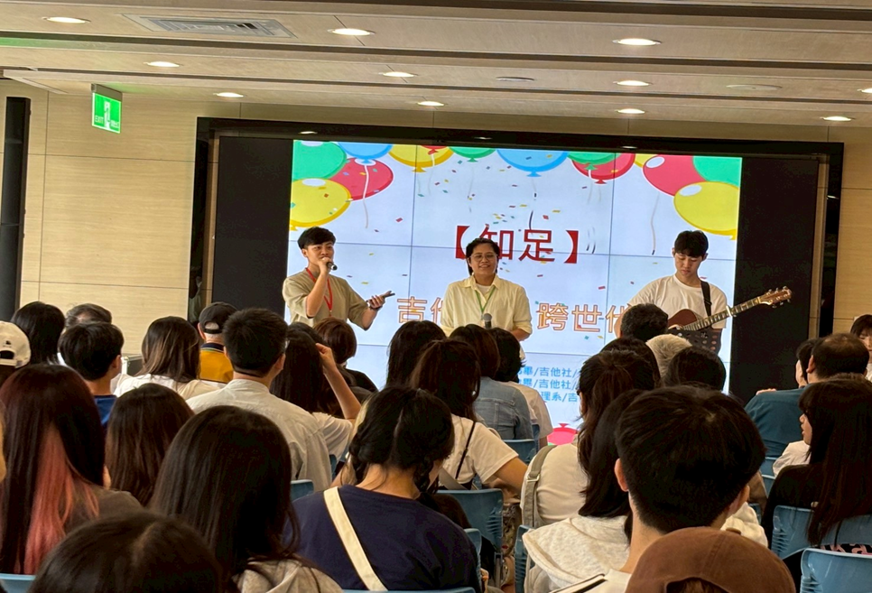 圖2-社團人回娘家開幕儀式,邀請畢業校友董恩亭學姐、杜靖宜學姐與現任吉他社林昕瑨社長共同帶動現場演唱「知足」,傳達對學校支持課外活動的感恩之情。
