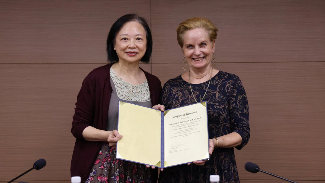 護理學院院長周繡玲(左)頒發謝狀給予美國約翰霍普金斯大學教授Cynda H. Rushton(右)。